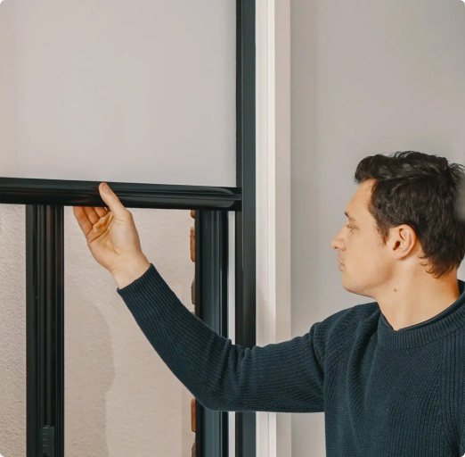 man lifting retractable blind