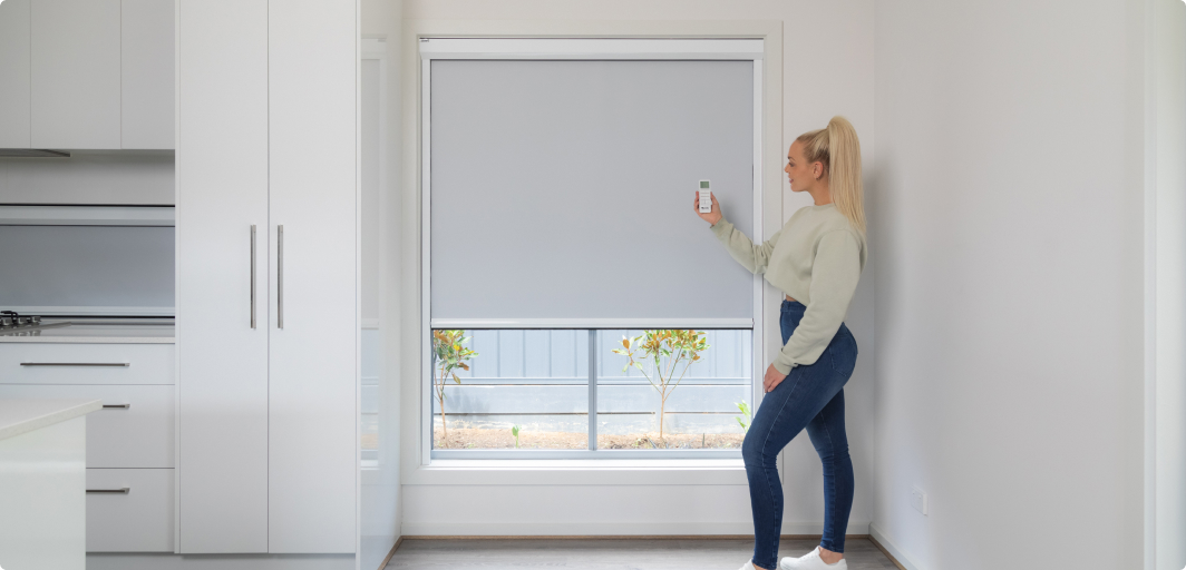 lady manipulating retractable blinds with a remote controller