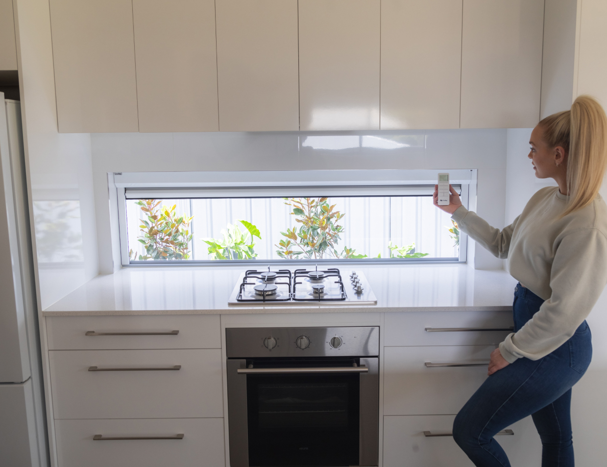 lady manipulating retractable blinds with a remote controller
