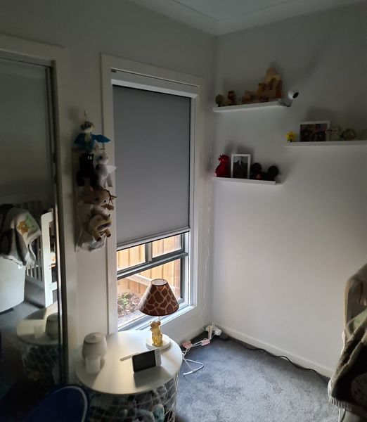 grey nursery blind partially pulled down