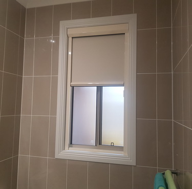 white bathroom blind partially pulled down