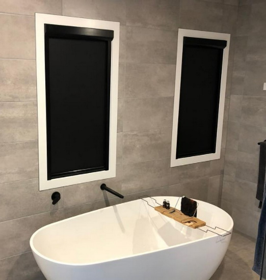 windows in bathroom covered by black blinds