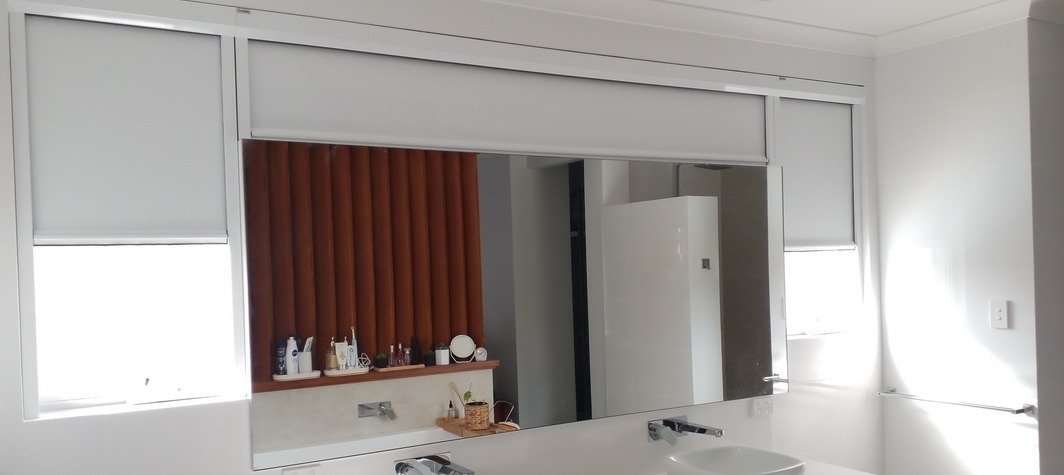 windows in bathroom partially covered by white blinds