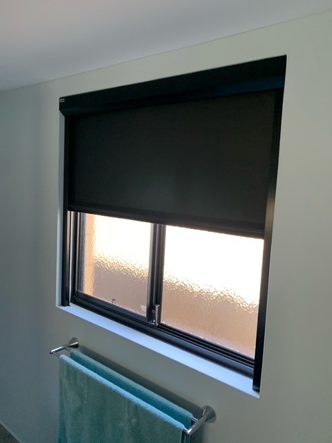 partially open retractable blind in bathroom
