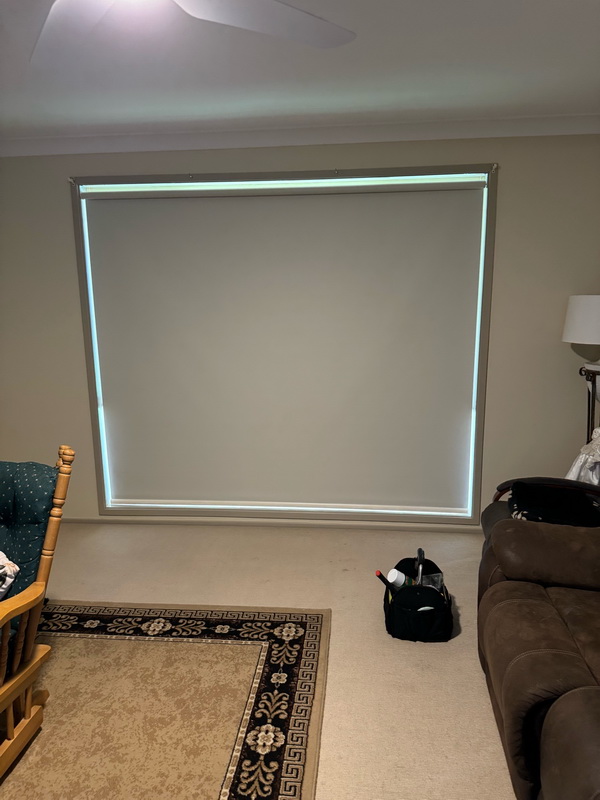 living room with a large window completely covered with an indiana roller blind