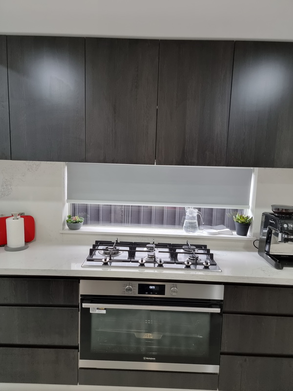 kitchen window with roller blind half closed